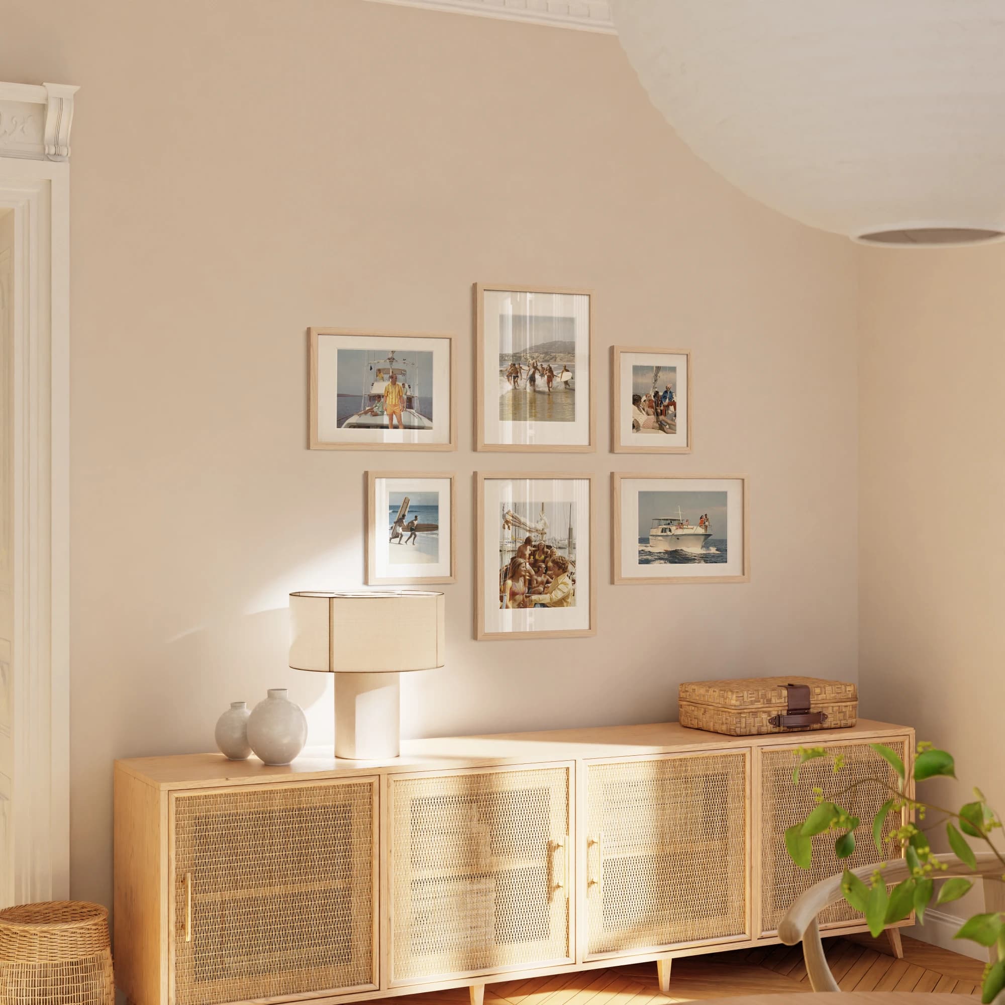 A gallery wall of oak-framed photographs above a wooden cabinet
