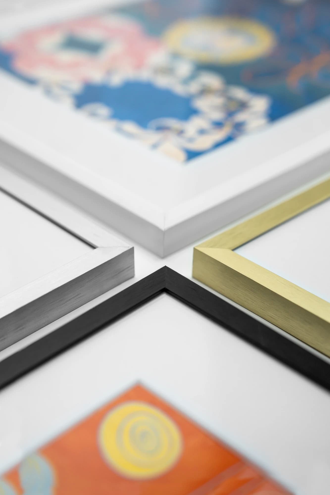 Close-up of metal frame corners in white, silver, gold, and black finishes