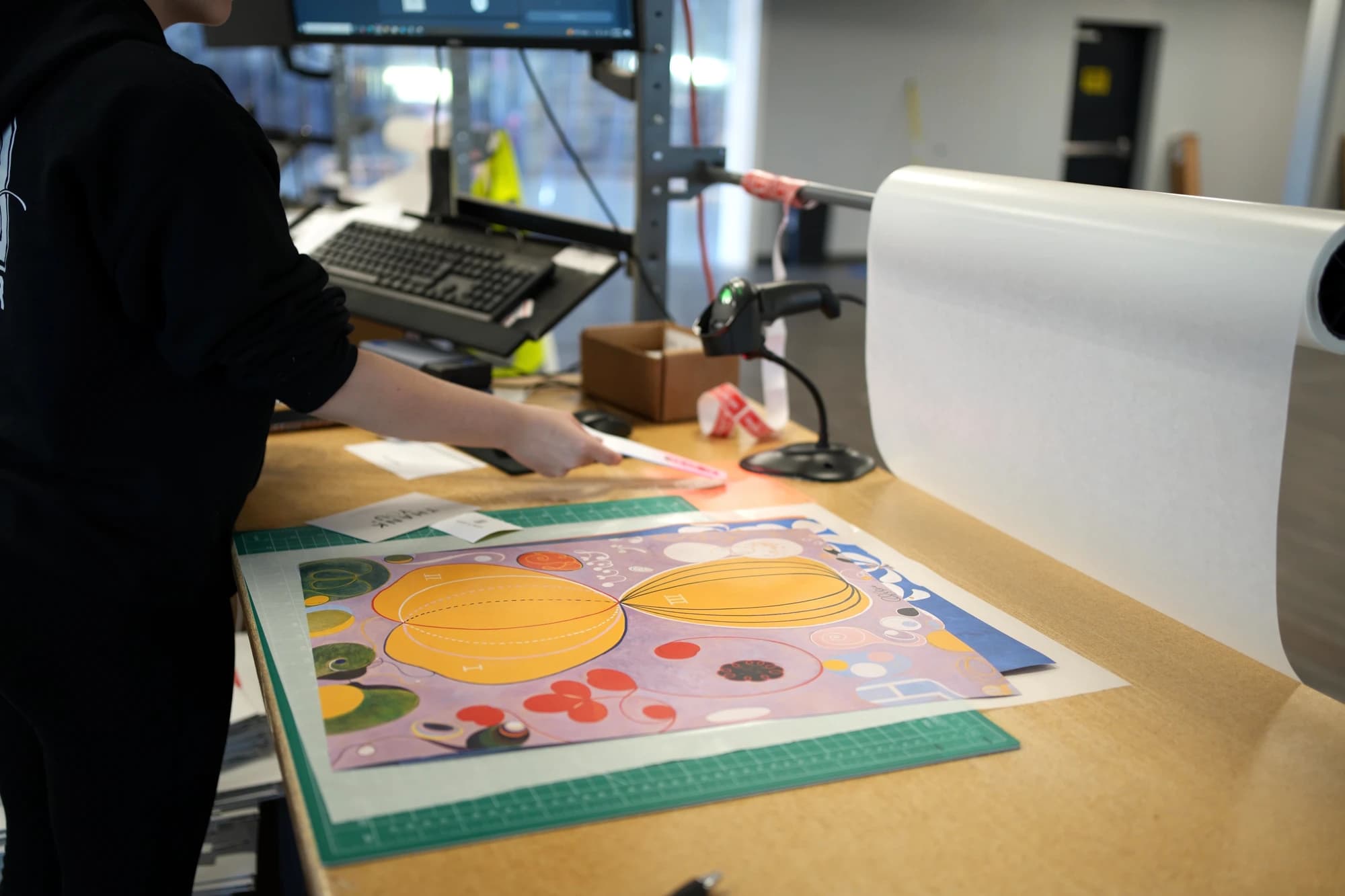An Artelo team member inspecting a freshly printed artwork